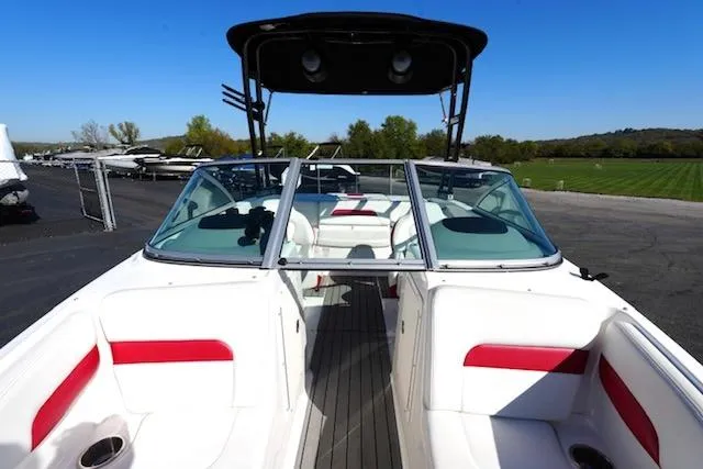 Slide: The Image of 2016 Chaparral H20 19 boat with red and white interior, parked outdoors. - 6