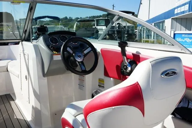 Slide: The Image of 2016 Chaparral H20 19 boat interior with red and white seating, steering wheel, and controls. - 9
