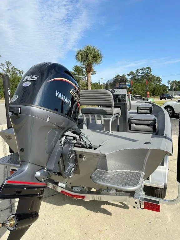 Slide: The Image of 2025 War Eagle Blackhawk 961 boat with Yamaha 115 engine, parked outdoors. - 12