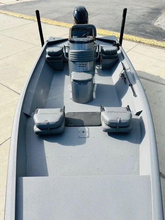 Slide: The Image of 2025 War Eagle Blackhawk 961 boat with seating and console, docked on pavement. - 7