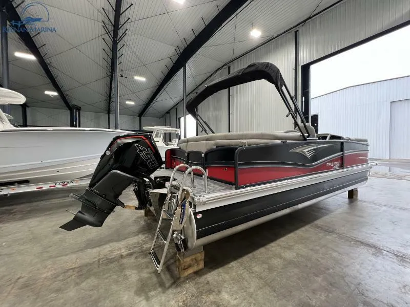 Slide: The Image of 2023 Premier 250 Intrigue RF pontoon boat in a spacious indoor marina. - 4