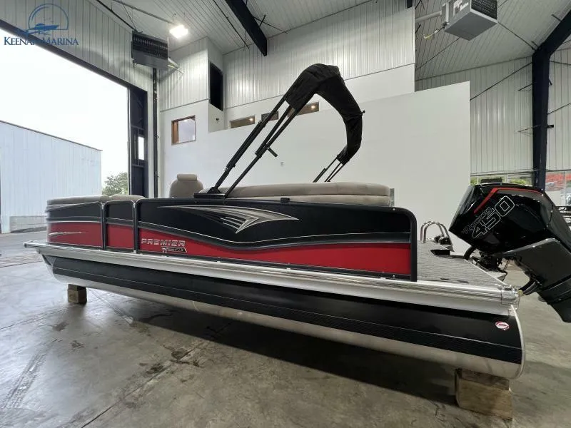 Slide: The Image of 2023 Premier 250 Intrigue RF pontoon boat in a showroom, featuring a sleek design. - 5