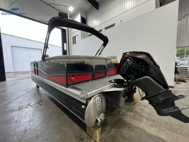 Slide: The Image of 2023 Premier 250 Intrigue RF pontoon boat with powerful outboard motor in a marina setting. - 9