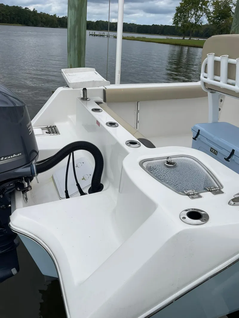 Slide: The Image of 2018 Tidewater 232 Adventure boat with motor, docked by a serene lake. - 15