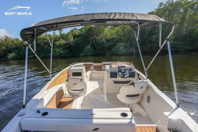 Slide: The Image of 2023 Starcraft SVX 231 OB DH boat on calm river with canopy and seating. - 10