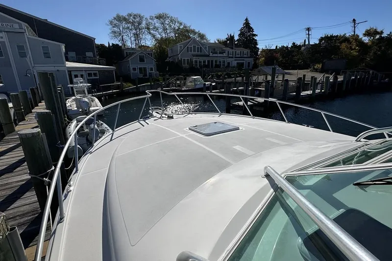 Slide: The Image of 2008 Cabo 40 boat docked at a marina with waterfront houses in the background. - 16
