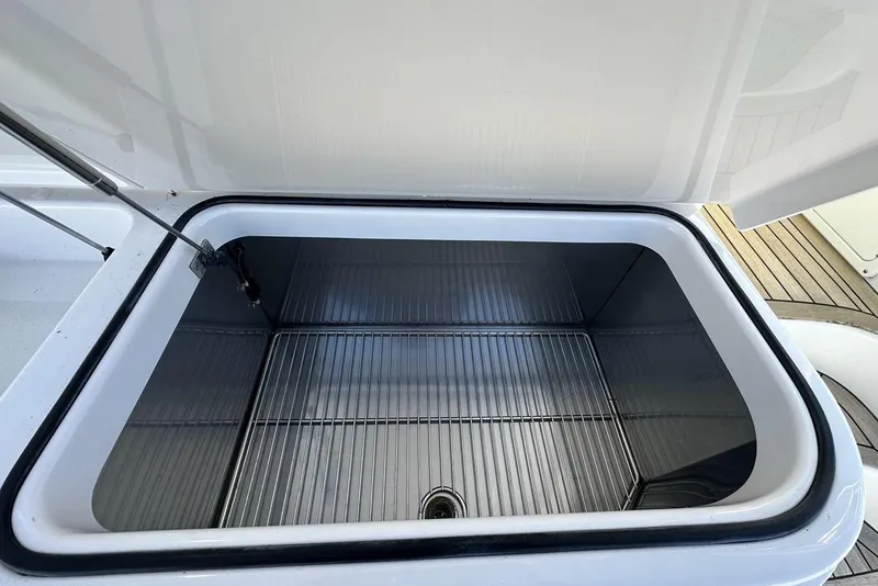 Slide: The Image of Open storage compartment on a 2008 Cabo 40 boat, featuring a wire rack. - 21