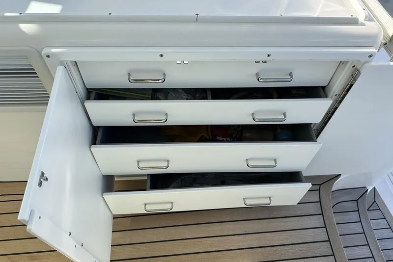 Slide: The Image of Open storage drawers on a 2008 Cabo 40 boat with wooden flooring. - 25