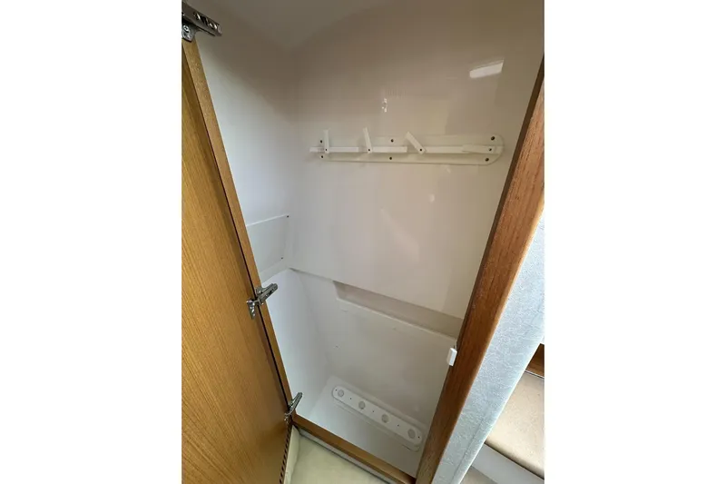 Slide: The Image of Empty storage closet inside 2008 Cabo 40 boat, featuring wooden door and wall hooks. - 36