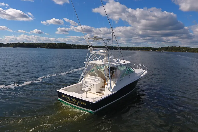 Slide: The Image of 2008 Cabo 40 boat cruising on a sunny day with blue skies and clouds. - 4