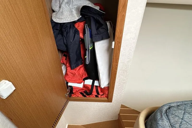 Slide: The Image of Storage compartment in a 2008 Cabo 40 boat, filled with jackets and gear. - 45