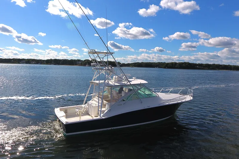 Slide: The Image of 2008 Cabo 40 boat cruising on a sunny day with blue skies and clouds. - 5