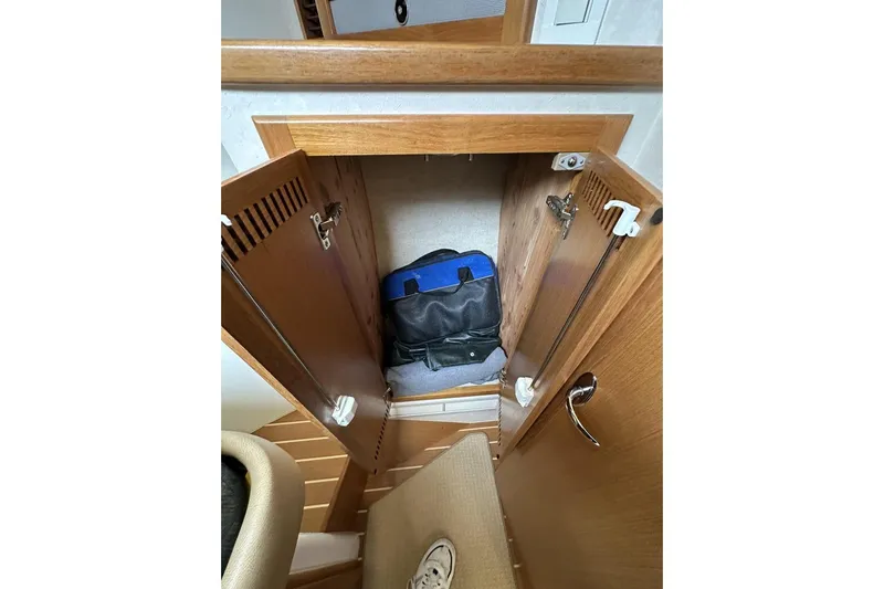 Slide: The Image of Wooden cabinet interior on a 2008 Cabo 40 boat, storing a blue and black bag. - 50