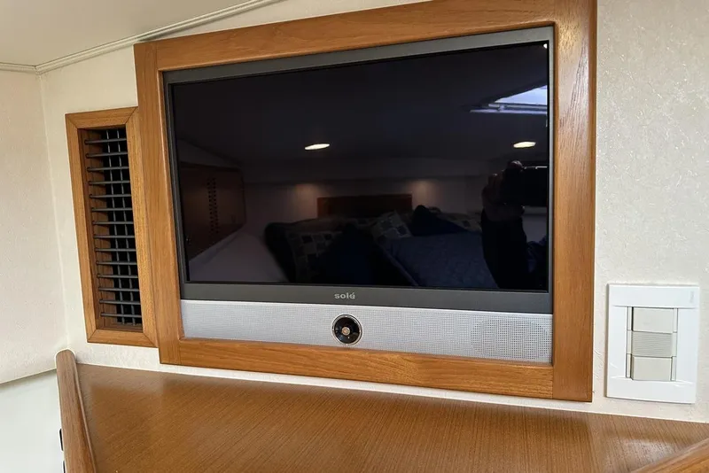 Slide: The Image of Wall-mounted TV in a 2008 Cabo 40 yacht interior, featuring wooden frame and ventilation. - 54