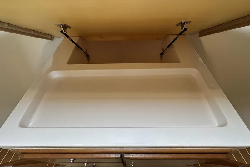 Slide: The Image of 2008 Cabo 40 interior storage compartment with open lid and hydraulic hinges. - 55