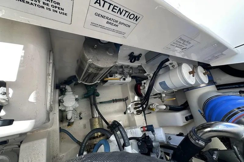 Slide: The Image of Engine compartment of a 2008 Cabo 40 boat, showcasing mechanical components and warning labels. - 70