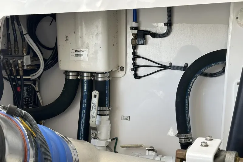 Slide: The Image of Engine compartment of a 2008 Cabo 40 boat, featuring hoses and mechanical components. - 71