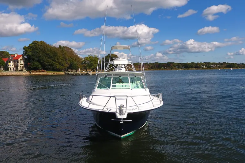 Slide: The Image of 2008 Cabo 40 boat on calm water with scenic shoreline and blue sky. - 8
