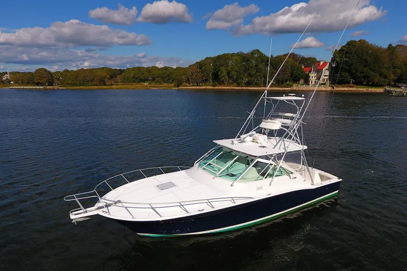 Slide: The Image of 2008 Cabo 40 boat on calm water with scenic shoreline background. - 9