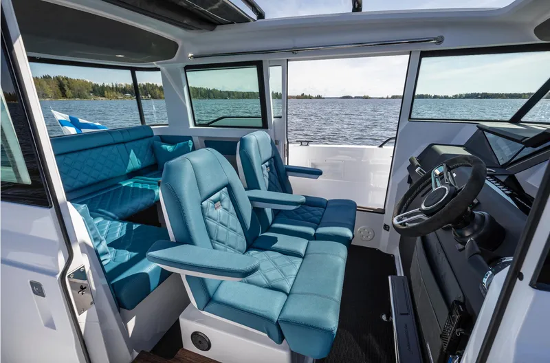 Slide: The Image of 2023 Axopar 37 XC Cross Cabin Wet Bar interior with blue seating and lake view. - 14