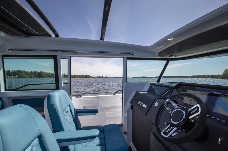 Slide: The Image of Interior view of 2023 Axopar 37 XC Cross Cabin Wet Bar, featuring blue seating and modern dashboard. - 16