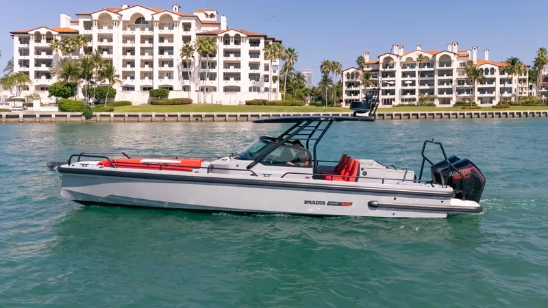 Slide: The Image of 2023 BRABUS Shadow 500 T-Top boat cruising near waterfront apartments. - 6