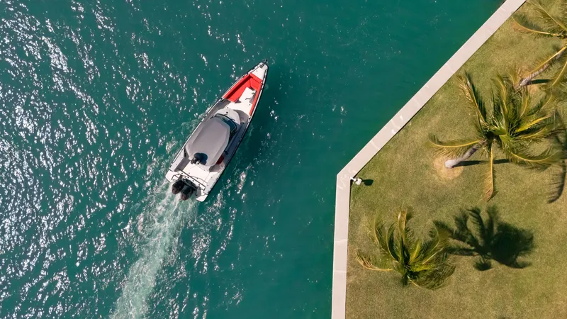 Slide: The Image of Aerial view of 2023 BRABUS Shadow 500 T-Top boat near a palm-lined shore. - 8