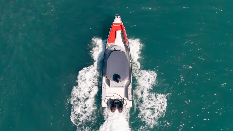 Slide: The Image of 2023 BRABUS Shadow 500 T-Top boat cruising on turquoise water, aerial view. - 9