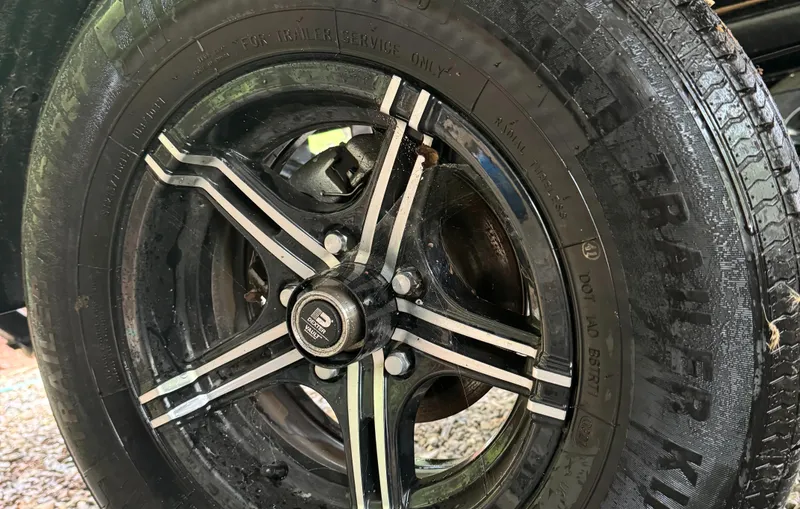 Slide: The Image of Close-up of a 2022 MasterCraft XT23 wheel with black and silver design. - 5