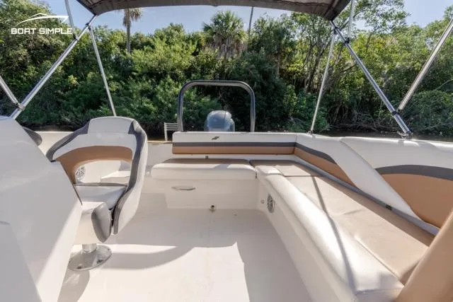 Slide: The Image of 2022 Starcraft SVX 191 OB boat interior with seating and canopy, surrounded by lush greenery. - 8