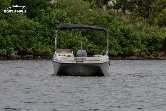 Slide: The Image of 2022 Starcraft SVX 211 OB boat on water, surrounded by lush greenery. - 2