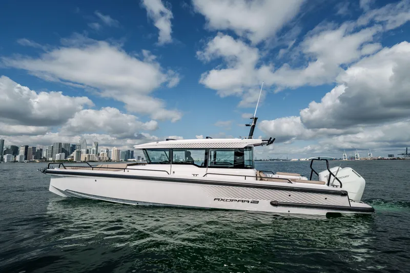 Slide: The Image of 2024 Axopar 37 XC Cross Cabin with Aft Cabin on water, city skyline background. - 3