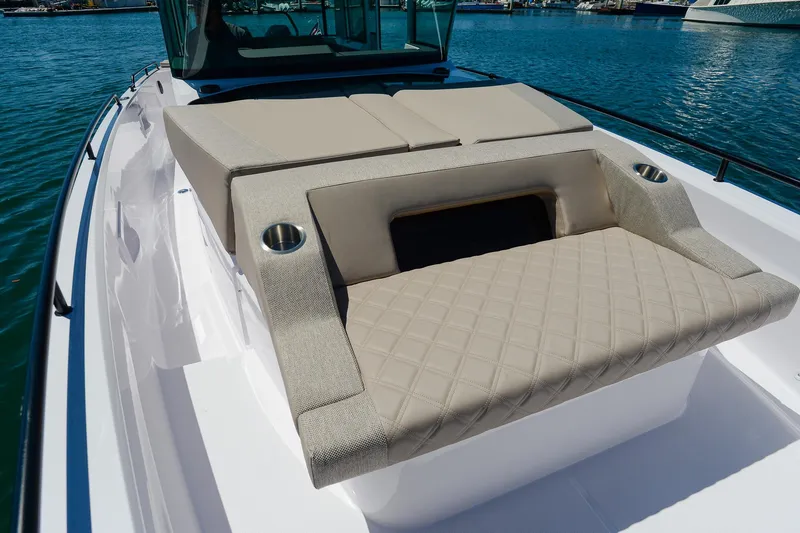 Slide: The Image of 2024 Axopar 37 XC Cross Cabin with aft cabin, featuring luxurious beige seating on deck. - 4