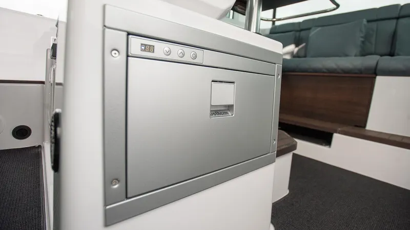 Slide: The Image of 2024 Axopar 37 XC Cross Cabin Wet Bar interior with helm and seating area. - 11