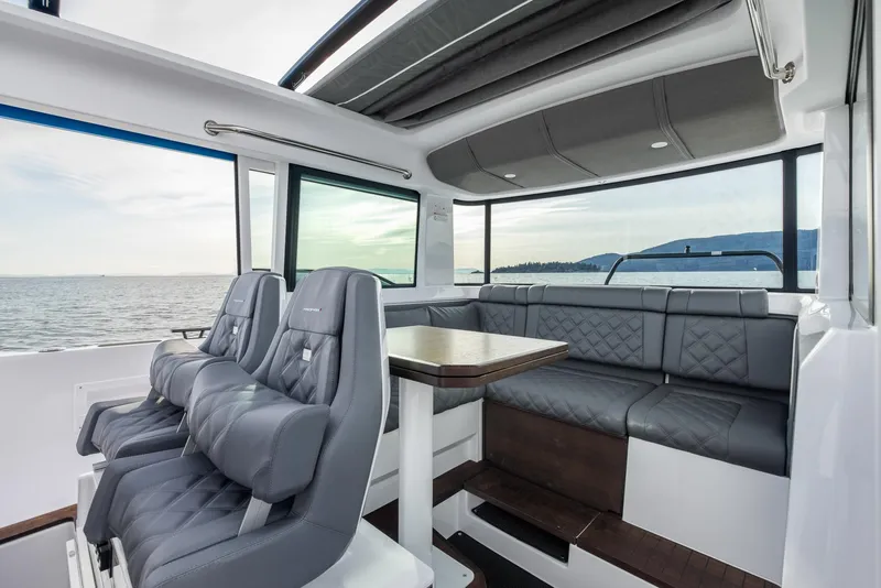 Slide: The Image of 2024 Axopar 37 XC Cross Cabin Wet Bar boat on calm water, marina background. - 4