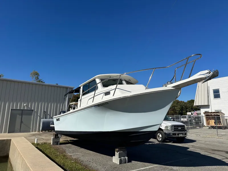 Slide: The Image of 2022 Parker 2520 XLD Sport Cabin boat on blocks, outdoor storage. - 2