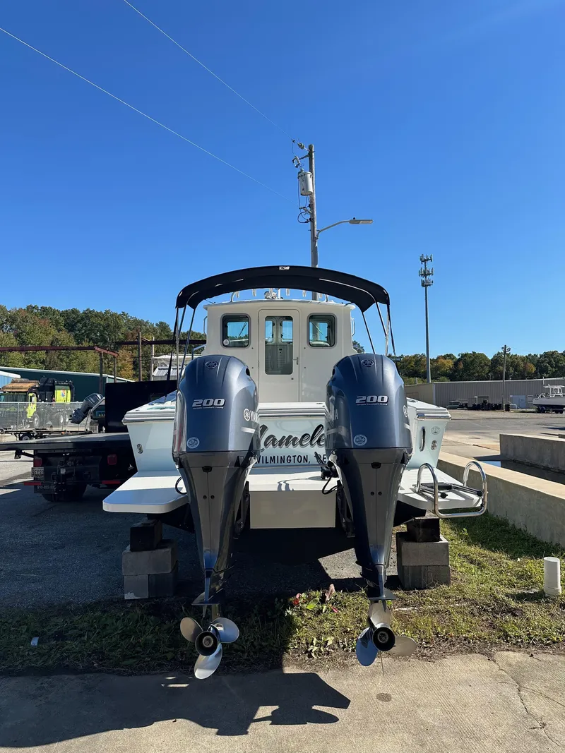 Slide: The Image of 2022 Parker 2520 XLD Sport Cabin boat with dual outboard motors, docked outdoors. - 4
