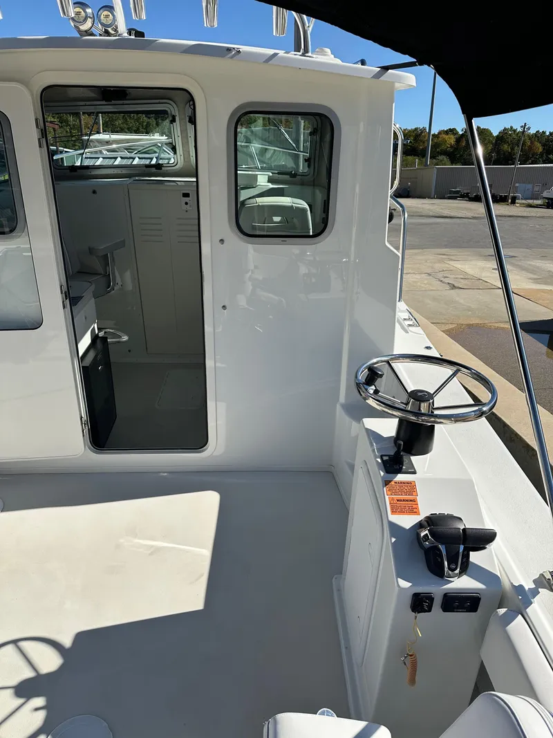 Slide: The Image of 2022 Parker 2520 XLD Sport Cabin boat interior with steering wheel and cabin entrance. - 8