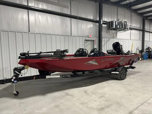Slide: The Image of 2025 Lund 1875 Renegade SS boat in a warehouse, red exterior, on a trailer. - 3