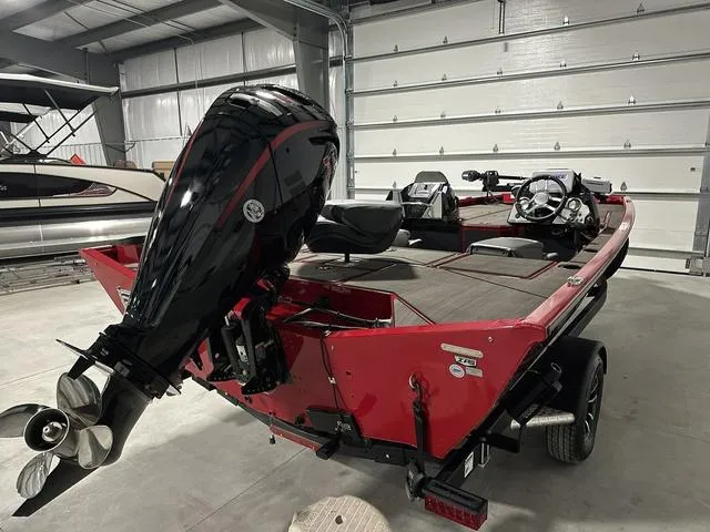 Slide: The Image of 2025 Lund 1875 Renegade SS boat in garage, red exterior, powerful outboard motor. - 6