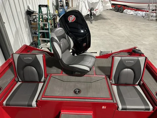 Slide: The Image of 2025 Lund 1875 Renegade SS boat interior with gray and red seating in a garage. - 9