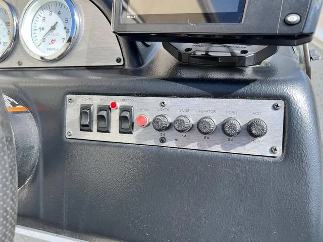 Slide: The Image of Dashboard controls of 2024 Lund 1600 Fury SS boat, featuring switches and gauges. - 12