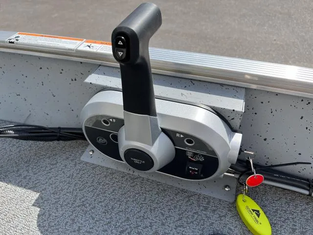 Slide: The Image of Throttle control of 2024 Lund 1600 Fury SS boat with key and safety lanyard. - 13