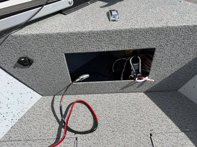 Slide: The Image of 2024 Lund 1600 Fury SS boat interior with open storage compartment and visible wiring. - 18