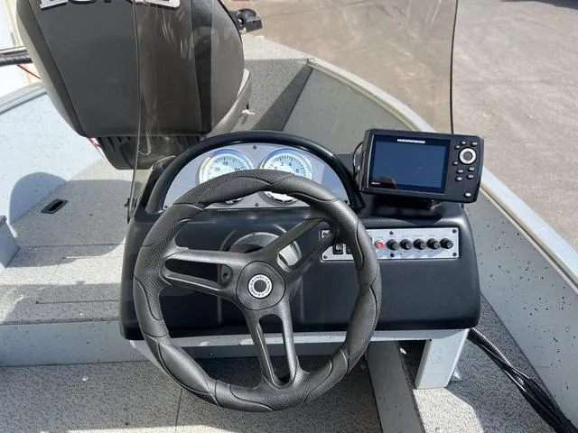 Slide: The Image of 2024 Lund 1600 Fury SS boat dashboard with steering wheel and navigation system. - 9