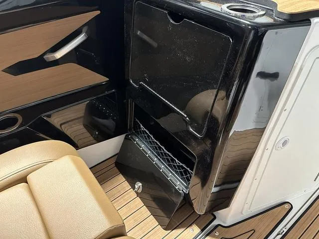 Slide: The Image of 2025 Yamaha Boats 222SD interior with sleek black panel and tan seating. - 17