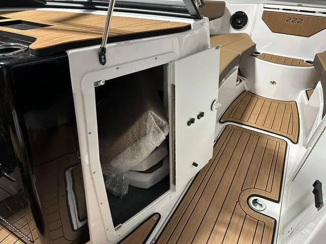 Slide: The Image of 2025 Yamaha Boats 222SD interior with open storage compartment and teak flooring. - 18