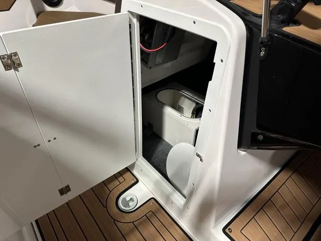Slide: The Image of 2025 Yamaha Boats 222SD interior storage compartment with wooden flooring. - 19