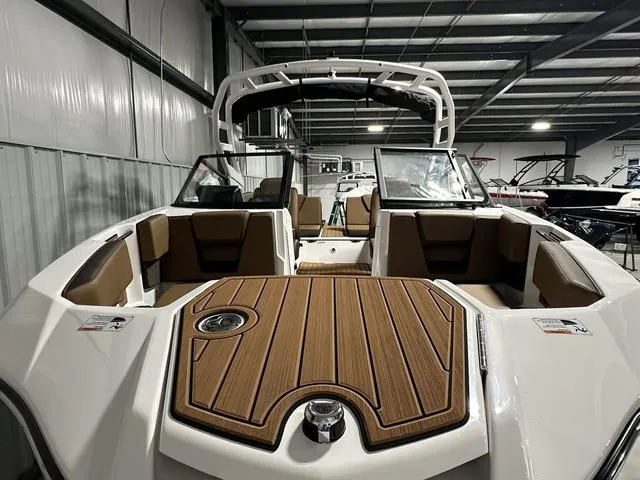 Slide: The Image of 2025 Yamaha Boats 222SD interior with sleek seating and modern design in a showroom. - 4