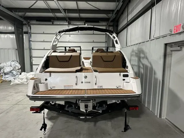 Slide: The Image of 2025 Yamaha Boats 222SD in a garage, showcasing rear deck and seating. - 5